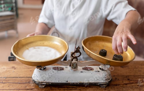 Preview: Unrecognizable baker woman weighing sugar with a weighing scales