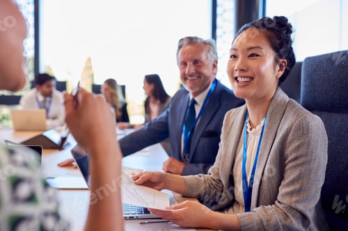 Preview: Multi-Cultural Business Team Meeting And Collaborating Around Table In Modern Office Building