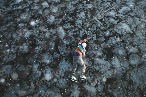 Preview: A Man In Ice Skates Lies On The Transparent Ice Of The Lake, View From Above, Aerial Photography