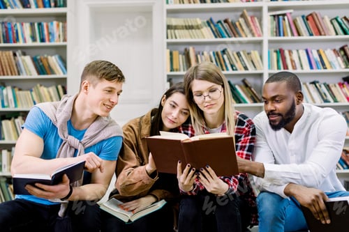 Preview: Group of young friends multiracial students, sitting in campus library, reading books while