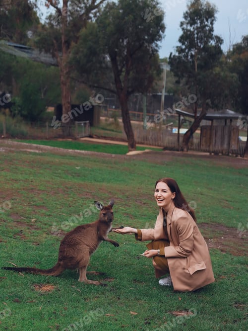 Preview: Woman in the reserve is playing with a kangaroo