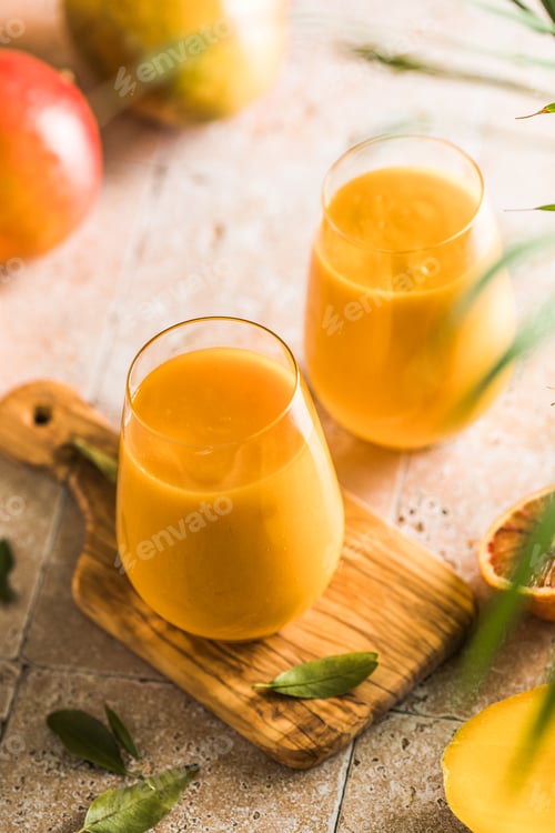 Preview: Two mango lassi or kesar milk in glasses. Indian healthy ayurvedic cold drink with mango.