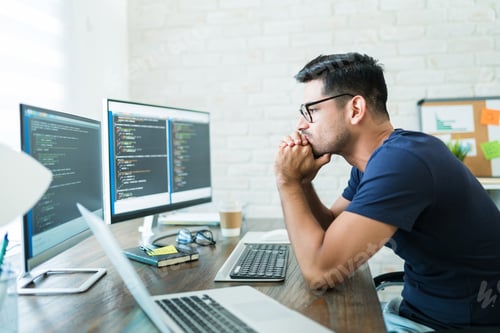 Preview: Attractive Male Coding On Computer At Desk