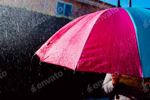 Preview: Colorful umbrella wet by heavy rain.