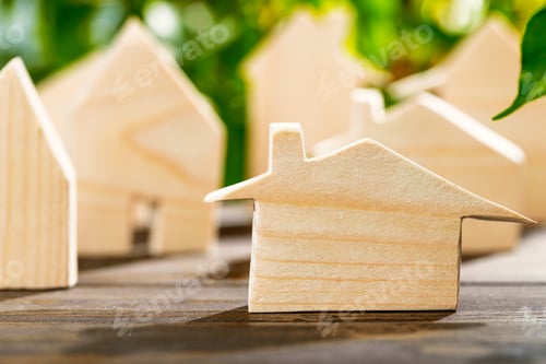 Preview: Toy wooden house on wooden table against foliage background