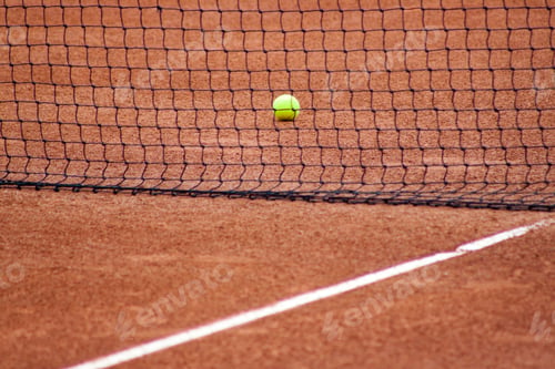 Preview: Tennis ball on the field near the net at daytime
