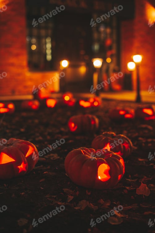 Preview: Beautiful smiling glow orange funny face carved pumpkins for Halloween holiday at night outdoor