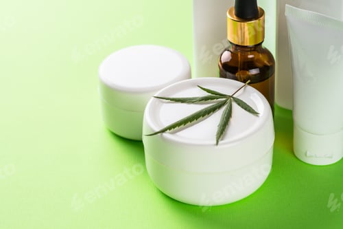 Preview: Cannabis cosmetic products on green background close up