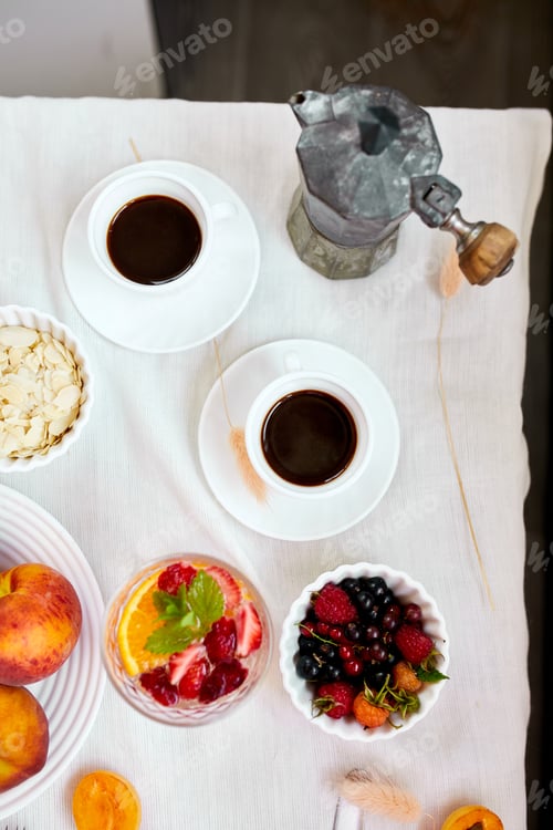 Preview: Two coffee cups and Italian coffee maker with croissant and fruits