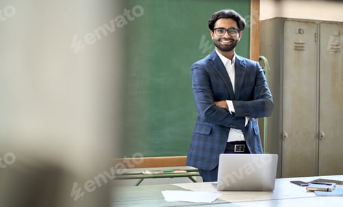 Preview: Happy young indian business man teacher wearing suit posing for portrait.