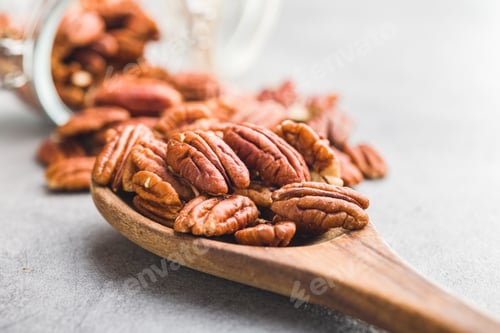 Preview: Peeled pecan nuts in wooden spoon.