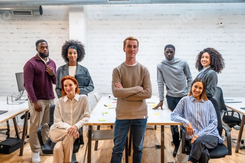 Preview: Confident man standing next to coworking colleagues