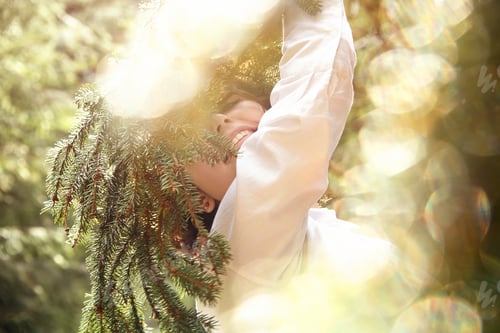 Preview: Cute charming girl in the summer in the forest in the glare of sunlight.