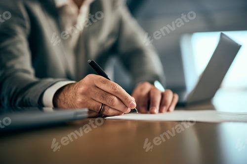 Vista previa: Foto de primer plano de un hombre de traje firmando un contrato con un bolígrafo.