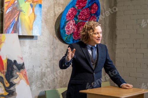 Preview: Confident auctioneer in elegant suit standing by tribune