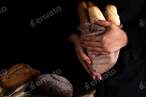 Preview: Baker woman holding rustic organic loaf of bread in hands - rural baker