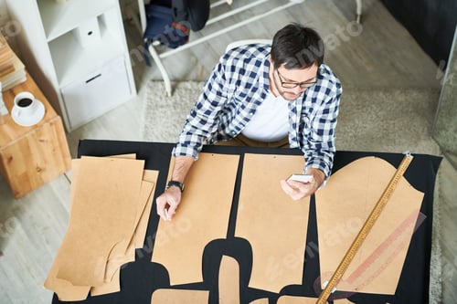 Preview: Tailor with phone making clothes patterns