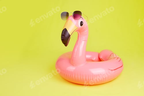 Preview: Inflatable flamingo with sunglasses on a yellow background, beach toy.
