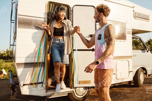 Preview: Multiracial couple smiling and holding hands by trailer