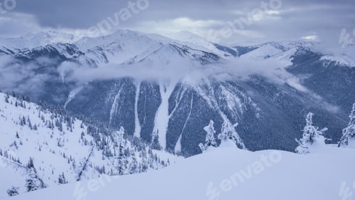 Preview: Hills with snow and clouds between mountains