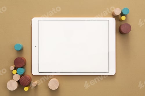 Preview: Modern tablet and wooden toys on brown background, flat lay. Space for text