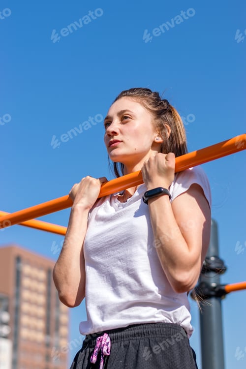 Preview: Young athletic woman going in for sports in an outdoor gym.Sports healthy lifestyle.Outdoor training