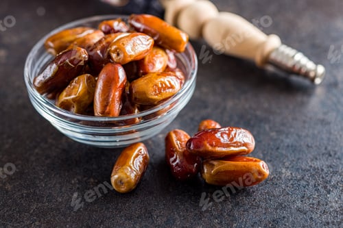 Preview: Dried dates fruit in bowl on black table.