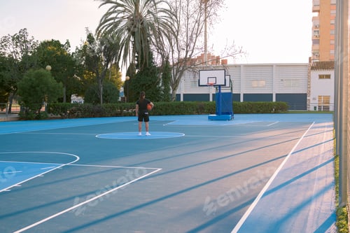 Preview: Basketball court with one person in the middle looking to the basket