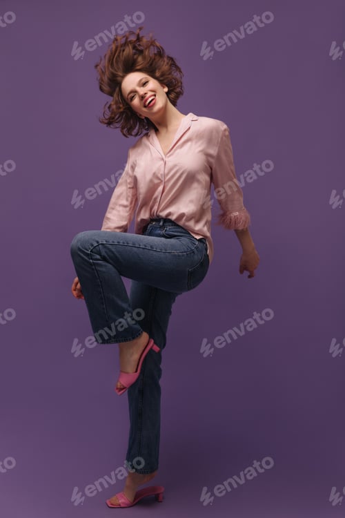 Preview: Full-length portrait of young lady in action isolated over purple background. Cute brunette with br