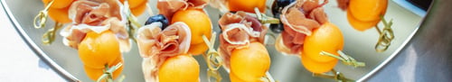 Preview: Delicious appetizers with prosciutto and peach at party. Close up. Catering event. Banner for site