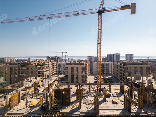 Preview: Aerial view of a cityscape with ongoing construction projects and completed residential buildings.