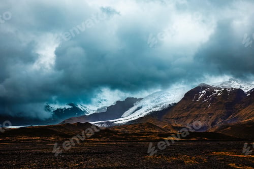 Preview: A dramatic Icelandic landscape with rugged mountains and moody clouds.