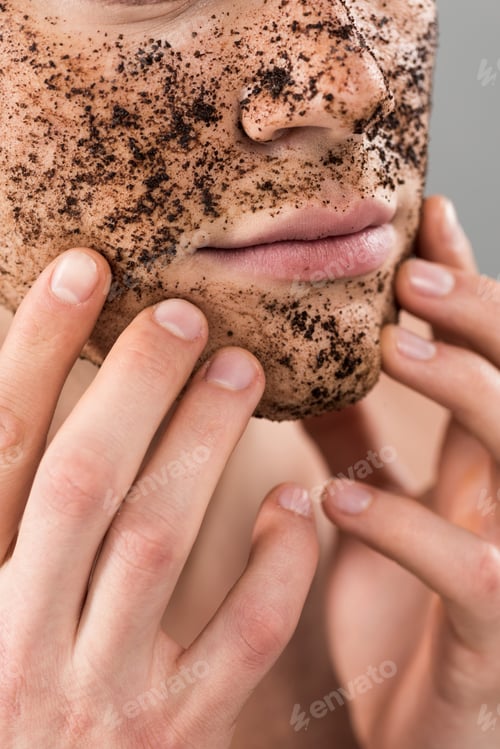 Preview: partial view of young man applying scrub isolated on grey