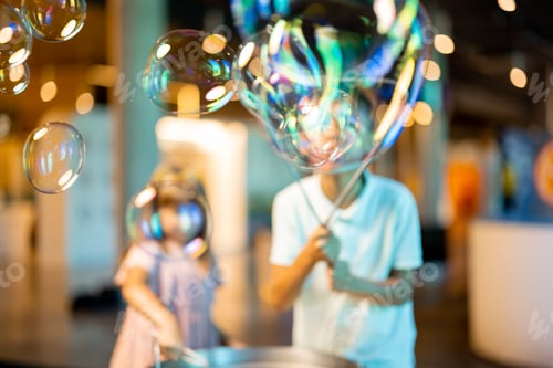 Preview: Little girl and boy make soap bubbles in science museum