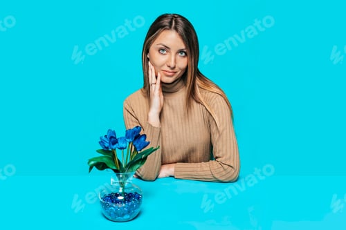 Preview: Studio portrait of a beautiful woman with blue flowers