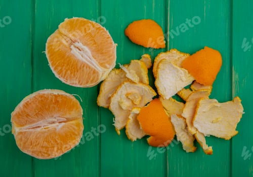 Preview: top view peeled orange with peel on green background