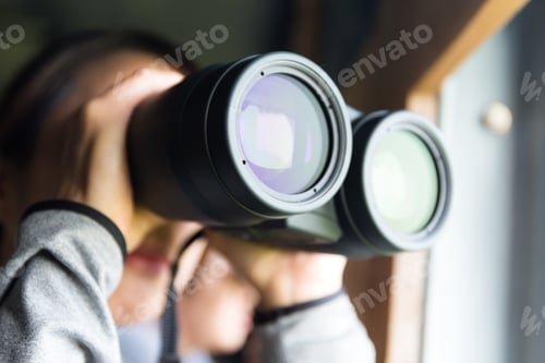 Preview: Young Woman use of the binoculars for birdwatching