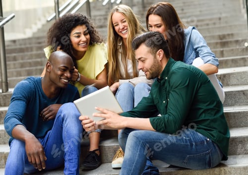 Preview: Multi-ethnic group of young people looking at a tablet computer