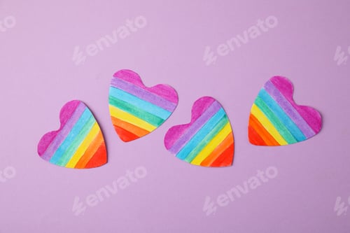 Preview: Rainbow hearts on color background, top view. Gay symbol