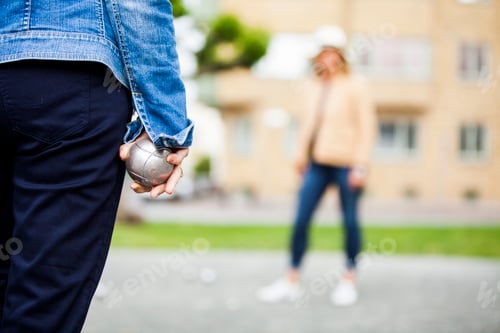 Preview: Senior women playing boule at field against building