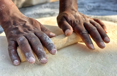 Preview: Diverse man making flatbread by hand outdoors in the warm desert morning sun