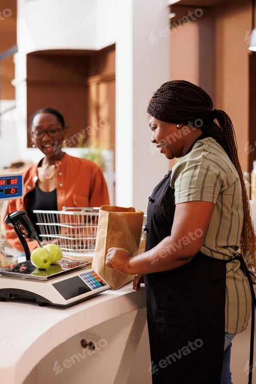 Preview: Cashier weighing green apples at store
