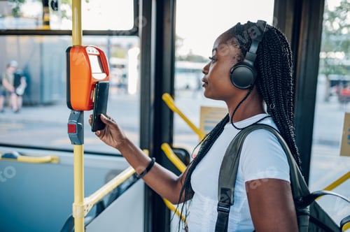 Preview: African american woman paying a bus ticket via smartphone during a ride