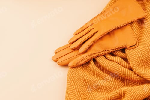 Preview: Flat lay of leather gloves and wool scarf on neutral background