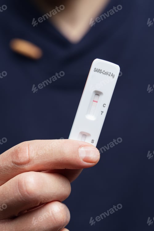 Preview: Hand holding a negative covid antigen rapid test