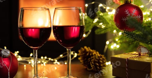 Preview: Christmas celebration. Red wine glasses, Xmas presents and decoration on table