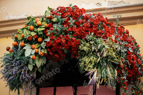 Preview: Stylish floral arch with roses, lavender, tangerines and straw on building exterior