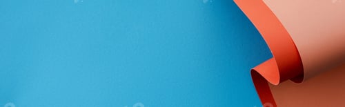 Preview: orange colorful paper swirl on blue background, panoramic shot