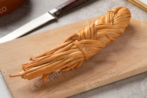 Preview: Smoked cheese braid from the Adyghe Republic on a cutting board
