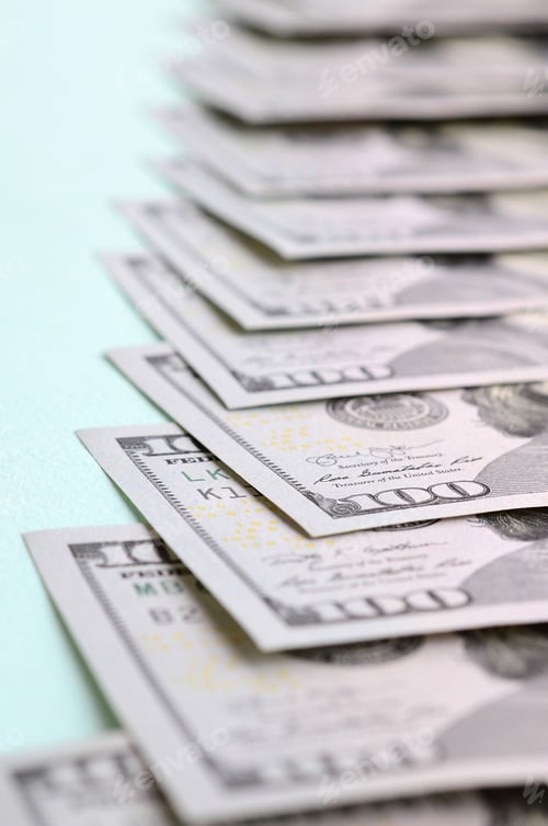 Preview: Row of a US dollar bills of a new design lies on a light blue background.